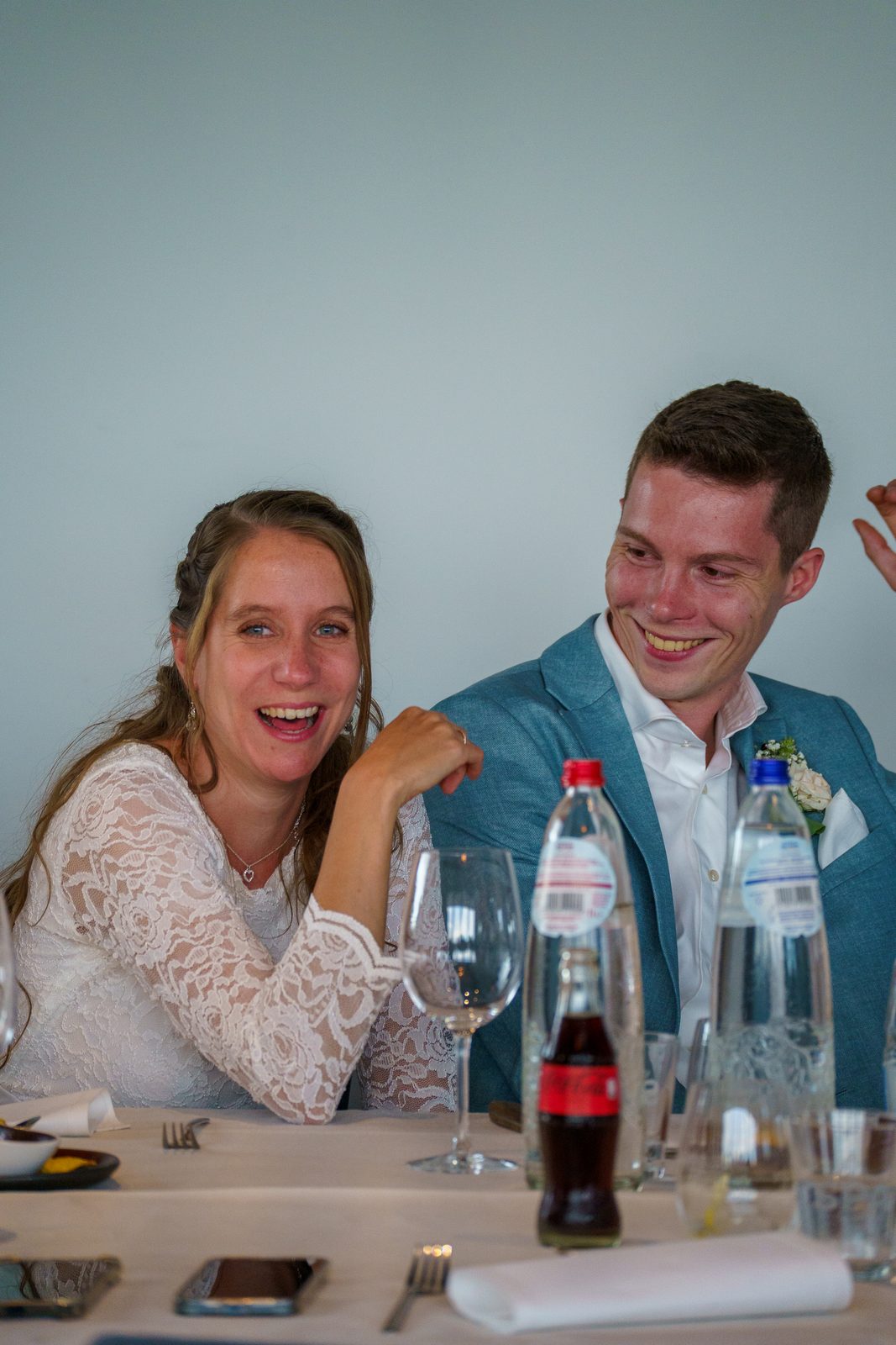 Bruidspaar lachend aan tafel